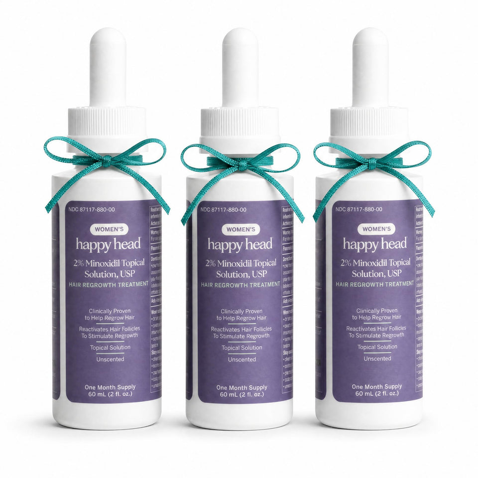 Happy Head front packaging shot showing clear 2% minoxidil bottles and label benefit