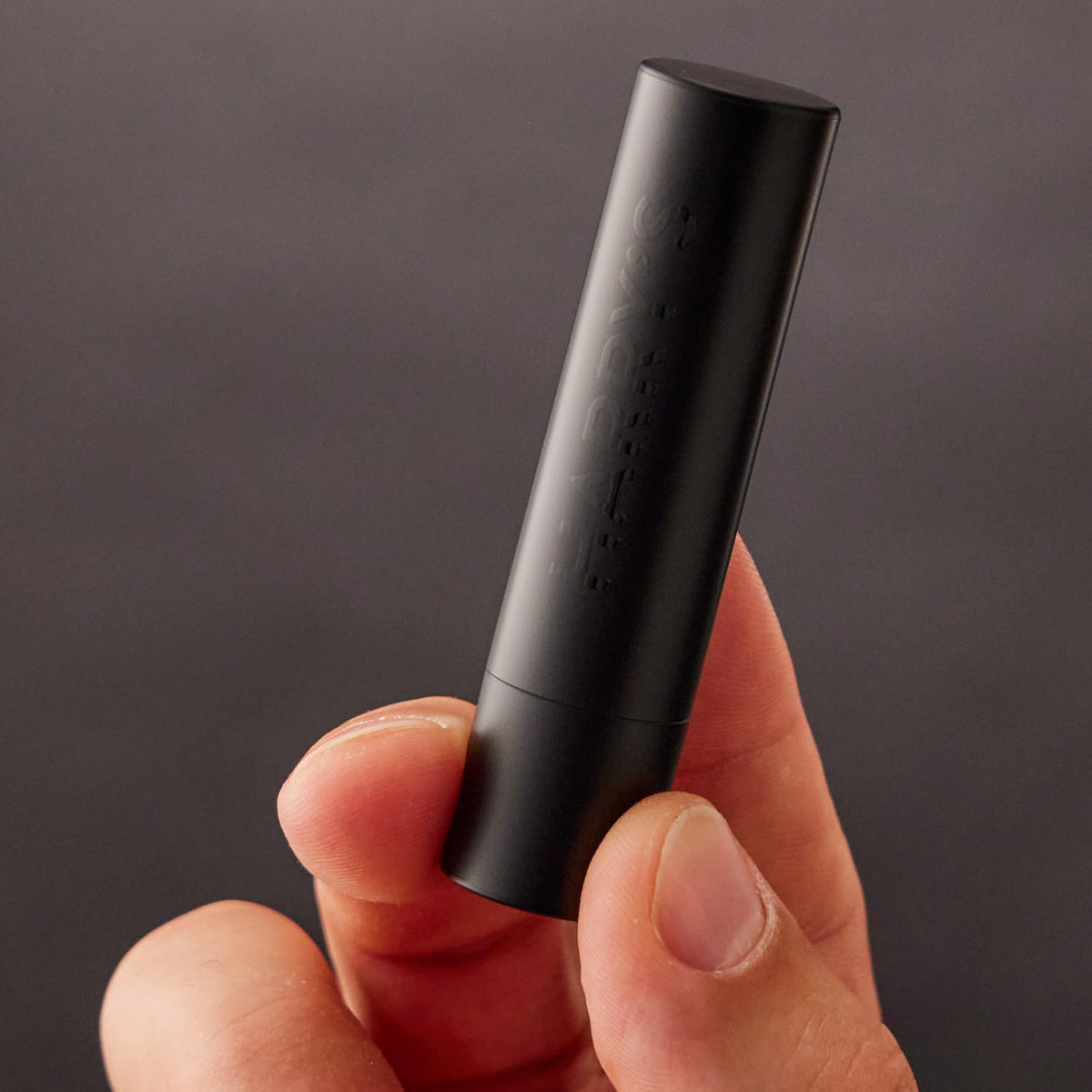 Harry's black lip balm being applied to lips for instant hydration benefit