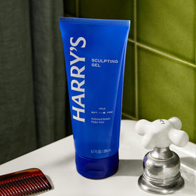 Harry's combing through hair with gel showing polished finish and neat styling