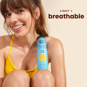Hawaiian Tropic clear mist spraying on arm for fast, invisible coverage
