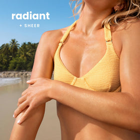 Hawaiian Tropic lotion texture on hand showing quick absorption and sheen