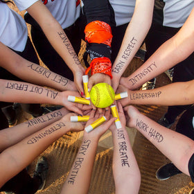 Heigble lip balm beside softball gear showing game-day convenience