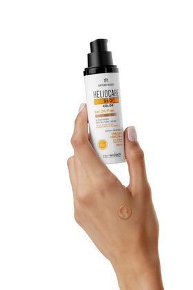 Model applying Heliocare tinted gel to cheek showing even tone and matte finish for makeup priming