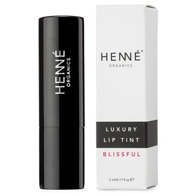 Henné Organics tube on vanity with flowers, evokes handcrafted luxury and everyday use