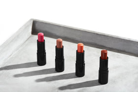 Henné Organics next to a common object showing compact travel-friendly size