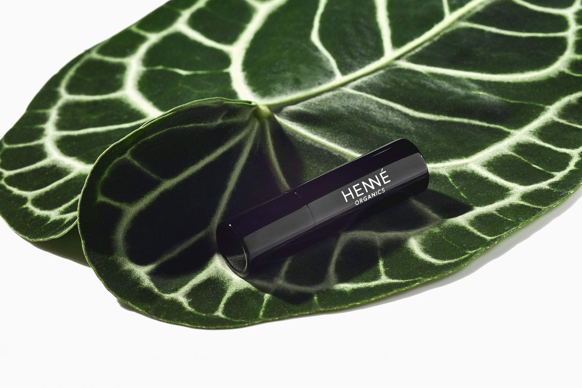 Henné Organics lip balm held in hand showing compact travel size benefit
