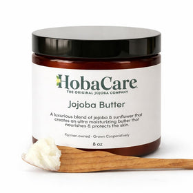HobaCare jar beside a hand for scale showing compact, travel-friendly 8 oz