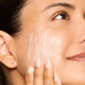 Honest Beauty open bottle with gel pouring to show smooth, non-greasy consistency