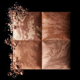 HOURGLASS bronzer beside everyday items showing compact size and portability