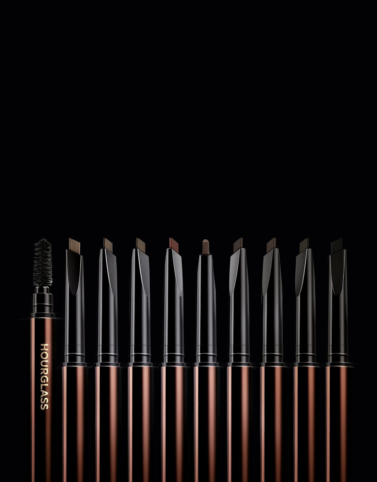 HOURGLASS model using pencil and spoolie to groom brows for natural, polished definition