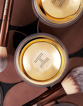 HOURGLASS powder applied with brush on hand showing natural blur and lightweight hold