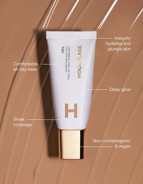 HOURGLASS bottle next to hand for scale showing portable size benefit