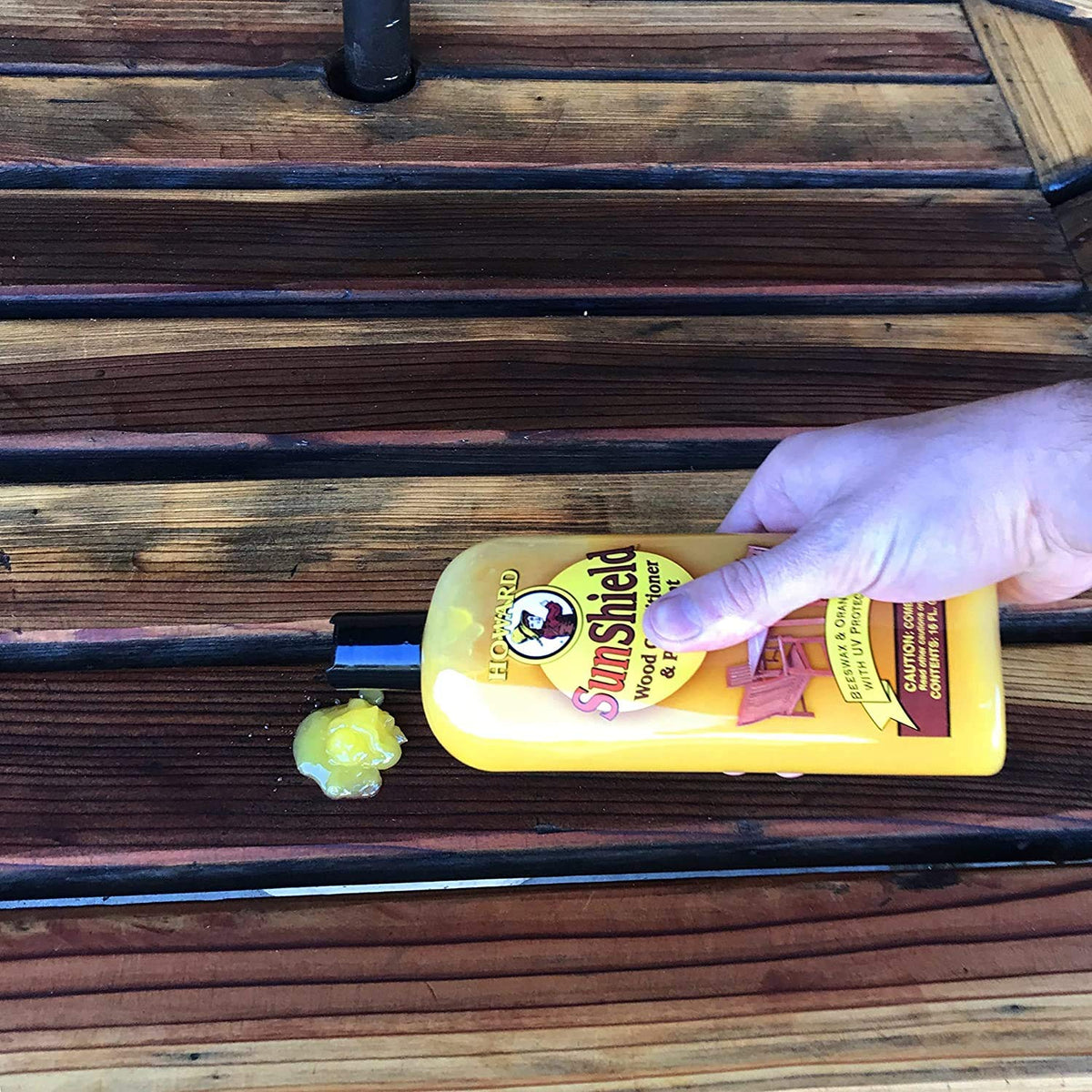 HOWARD 16oz bottle beside hand to show size and convenient handling