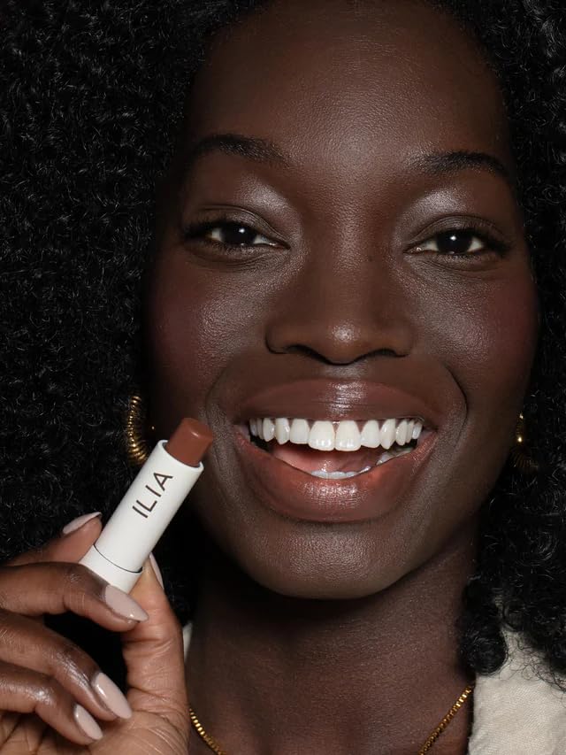 ILIA model smiling wearing Faded showing natural warm tint and fresh look
