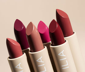 ILIA size comparison of Color Block lipstick beside a coin showing travel-friendly weight