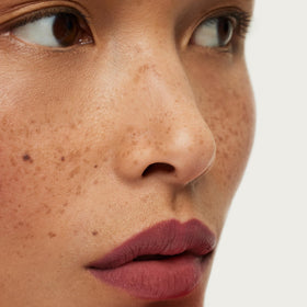 ILIA application on lips displaying cool mauve Rhyme and natural definition benefit