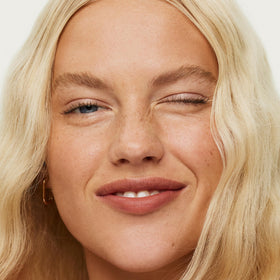 ILIA on-model lifestyle image demonstrating natural, hydrated lip finish