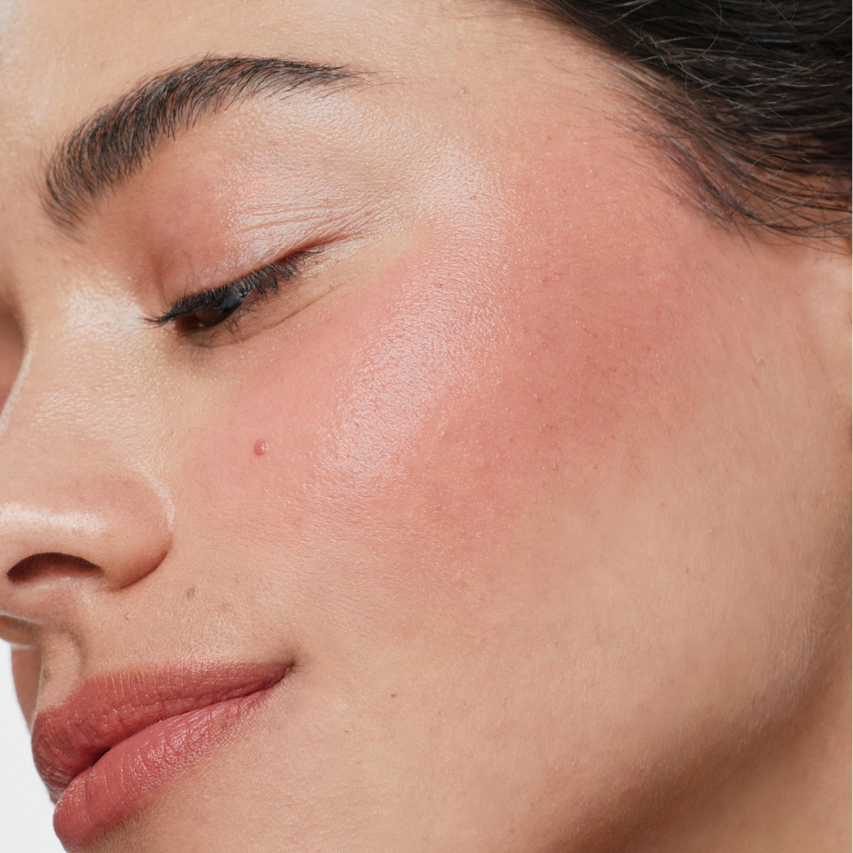 ILIA applying multi-stick to cheek for instant fresh color