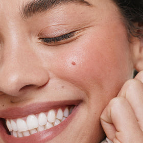 ILIA stick being blended onto a cheek, demonstrates natural-looking blush effect