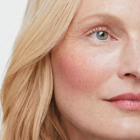 ILIA multi-stick being blended on cheek showing natural, buildable peach-pink color payoff