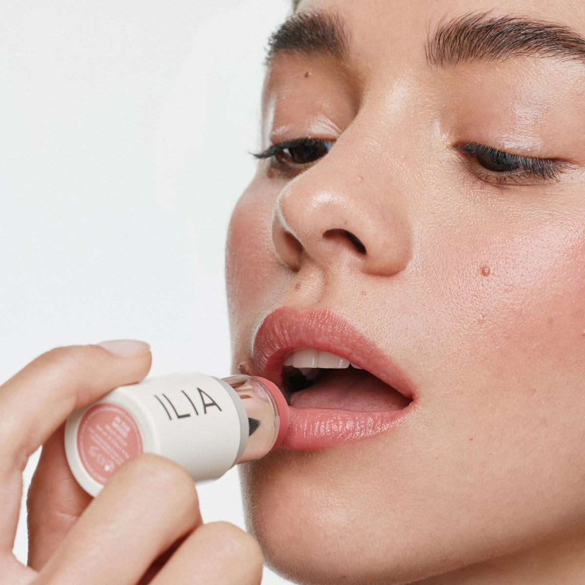 ILIA swatch on arm showing golden peach shade and blendable coverage