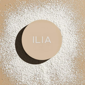 ILIA powder on a vanity with mirror showing natural everyday glow