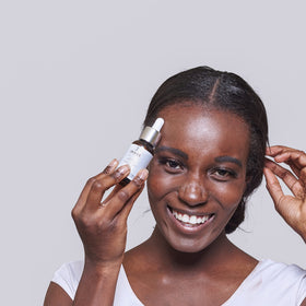 IMAGE Skincare bottle next to hand showing size and portable travel benefit