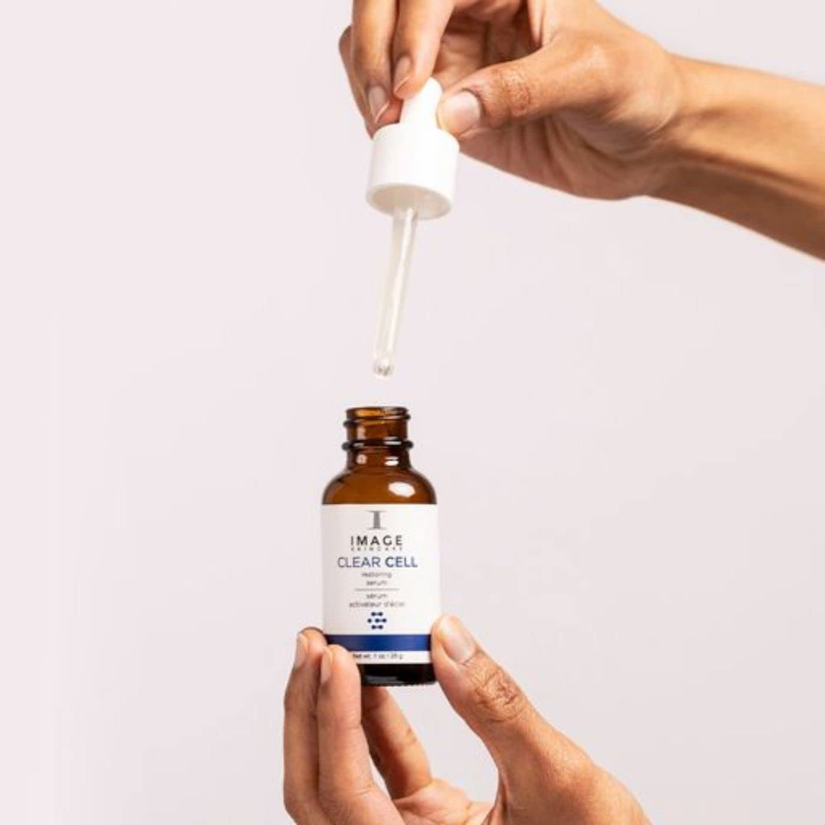 IMAGE Skincare clear cell in hand scale illustrating 1 oz size and travel-friendly convenience
