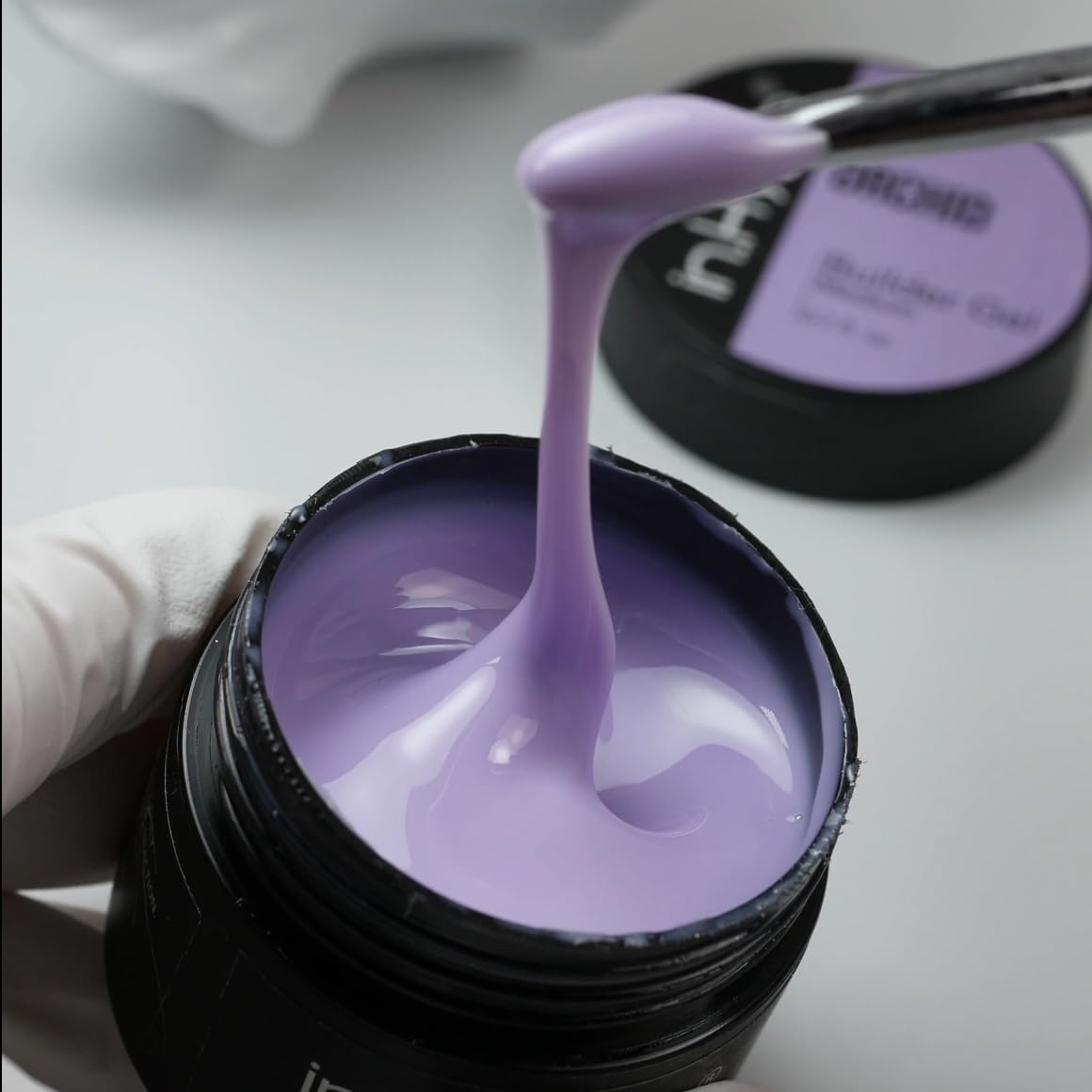 IN.HYPE finished manicure on hands displaying vibrant Purple Orchid color payoff