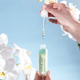 Indie Lee pump dispensing a controlled drop for easy application