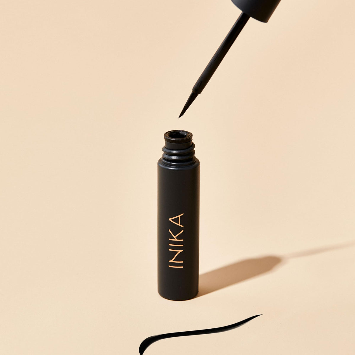 INIKA eyeliner beside coin showing compact size