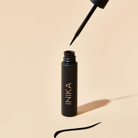 INIKA eyeliner beside coin showing compact size