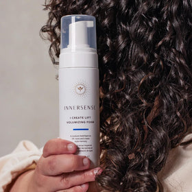 INNERSENSE bottles next to hand for scale showing compact travel-friendly sizes