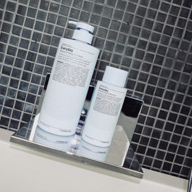 Hand holding J Beverly Hills 12 oz bottle to show scale and travel-friendly size benefit