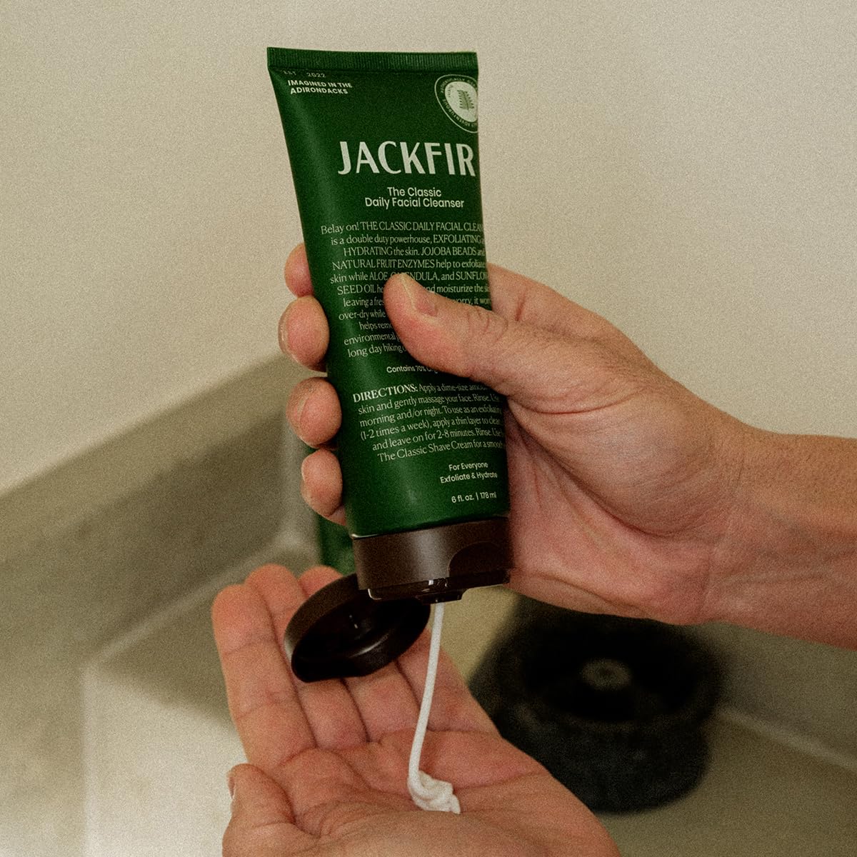jackfir tube held in hand showing 6 fl oz scale for size and portability benefit