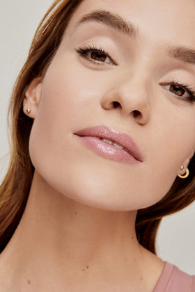 jane iredale lip swatch on model showing glossy pink, plumping effect