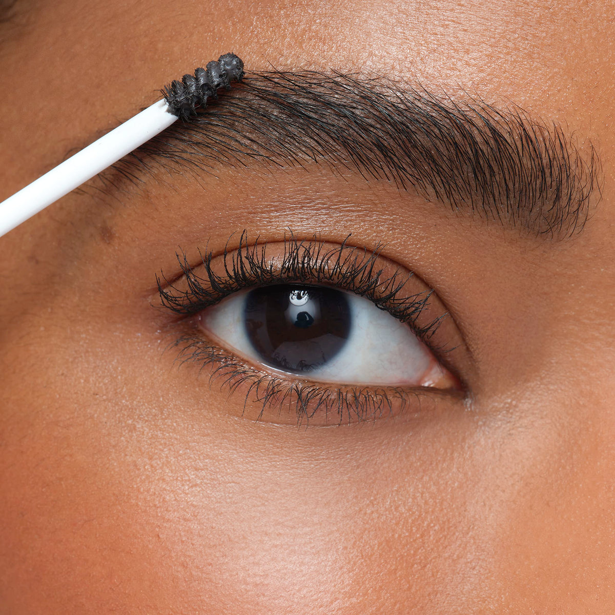 jane iredale brow gel with brush by mirror illustrating quick everyday styling