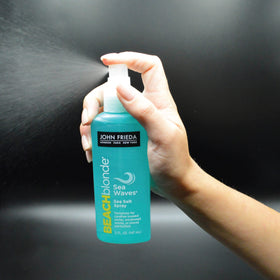 John Frieda bottle in hand showing 5 ounce scale and travel-friendly size