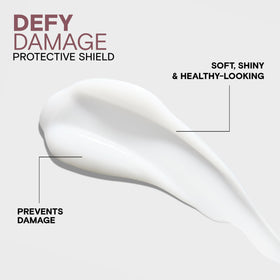 Joico Defy Damage bottle in hand for size comparison and travel-friendly benefit