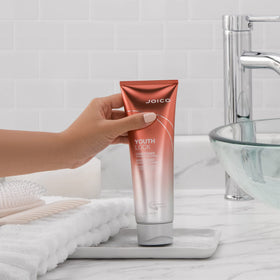 Joico YouthLock conditioner on bathroom shelf in lifestyle scene for daily routine