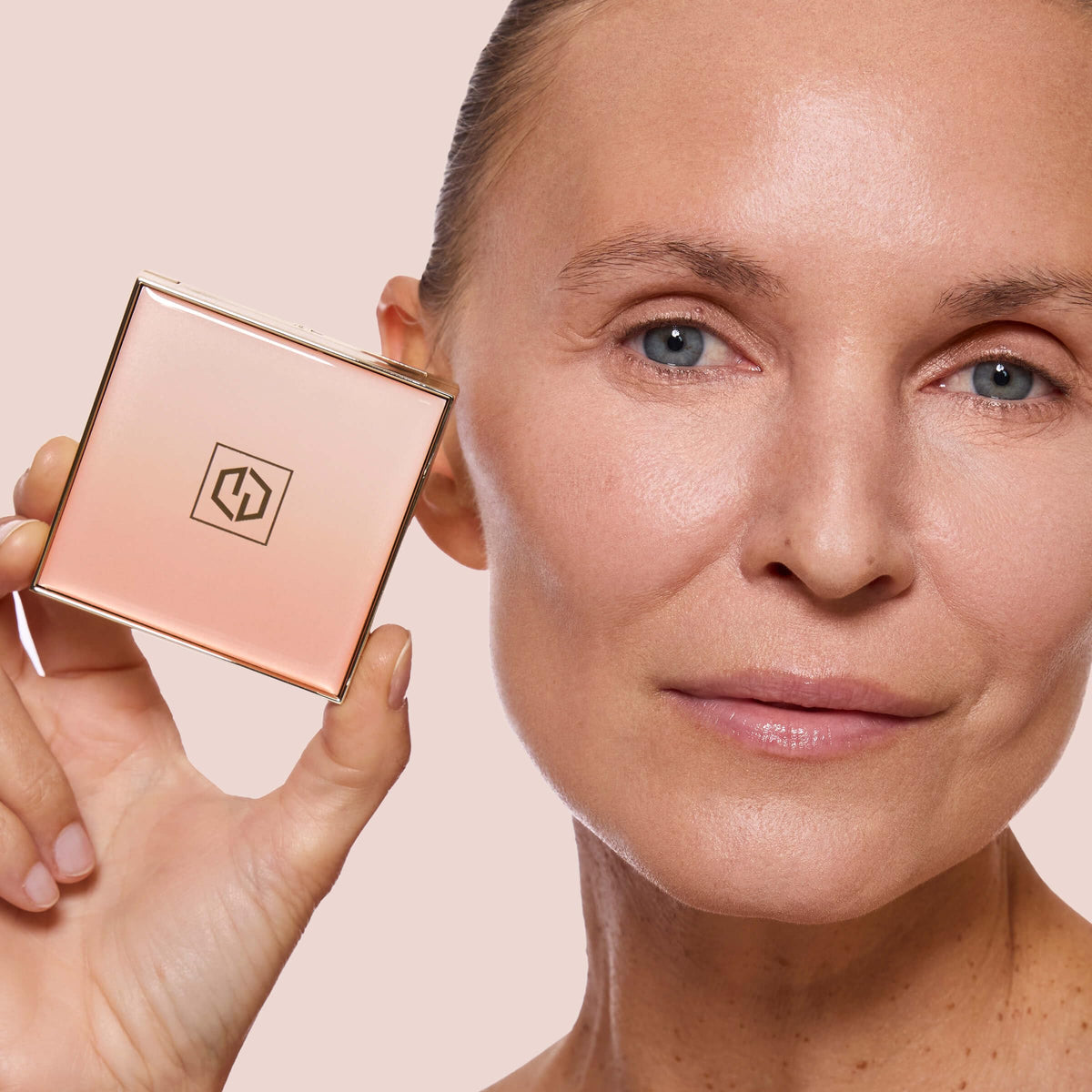 Jouer size and scale with compact next to a makeup brush for proportion