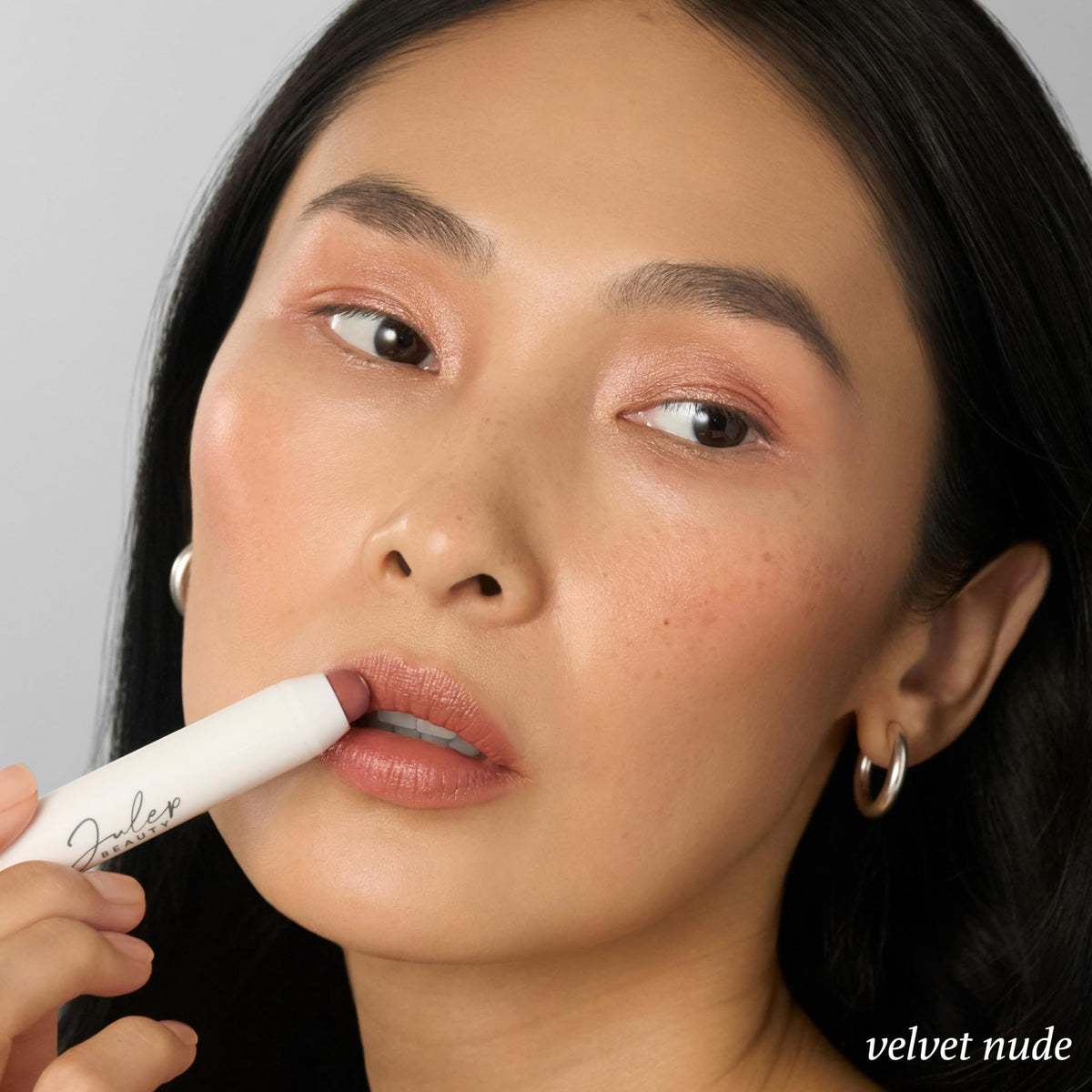 Julep swiped on lips showing Velvet Nude buildable, natural glossy color
