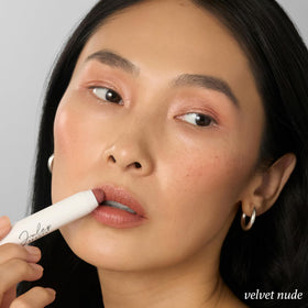 Julep swiped on lips showing Velvet Nude buildable, natural glossy color