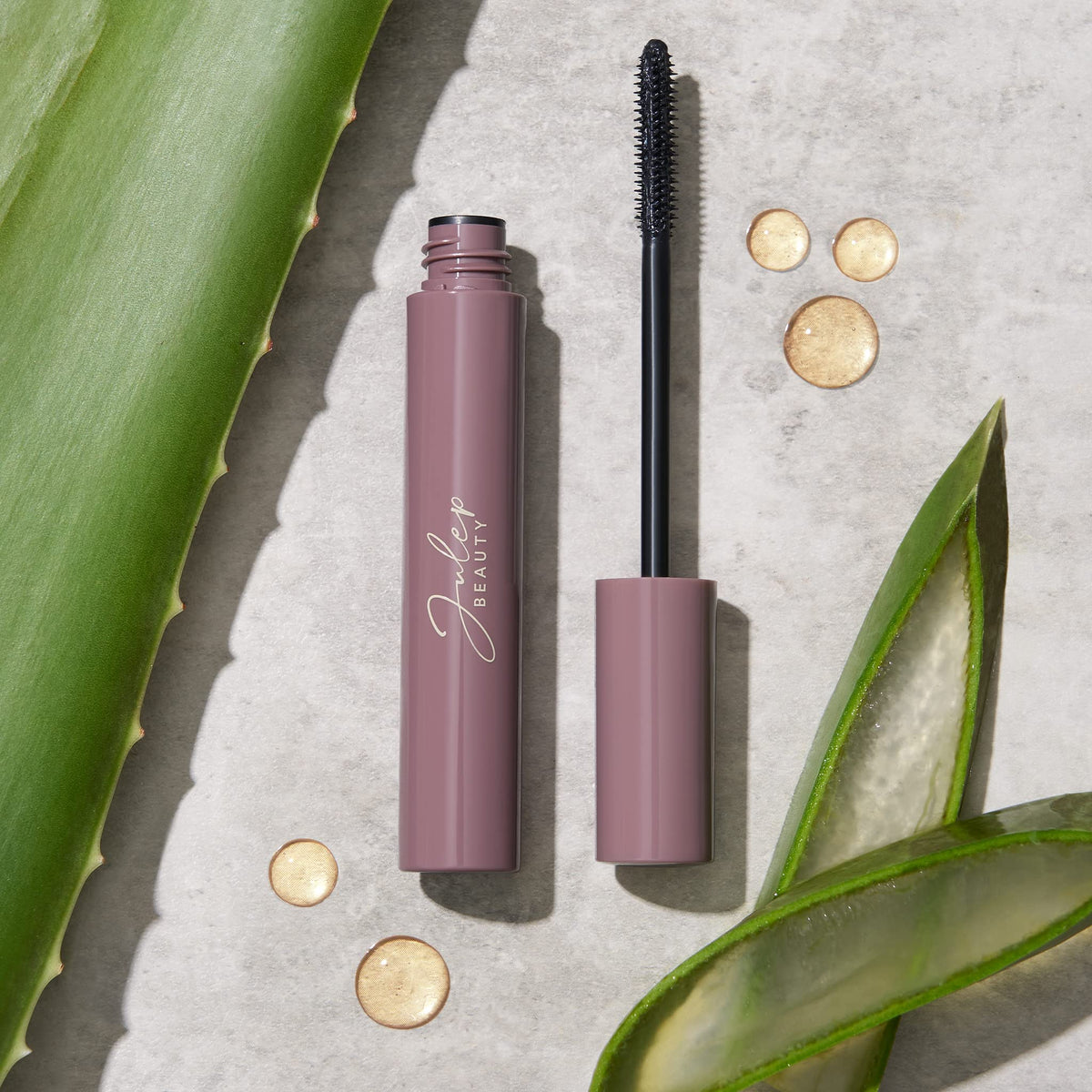 Julep mascara held next to finger to show compact size and travel-friendly benefit