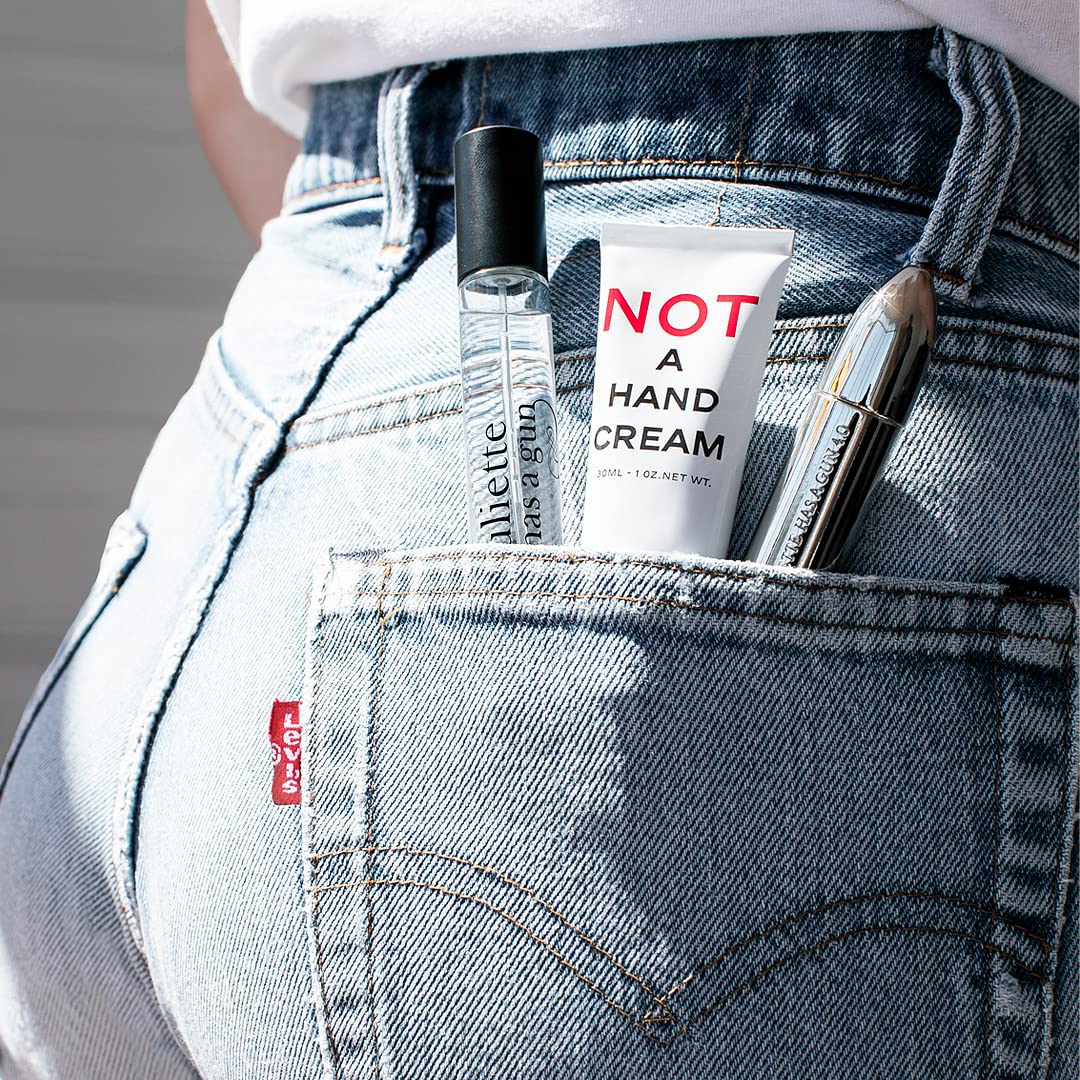 Juliette Has A Gun 1 oz tube next to a wallet for scale showing portable size