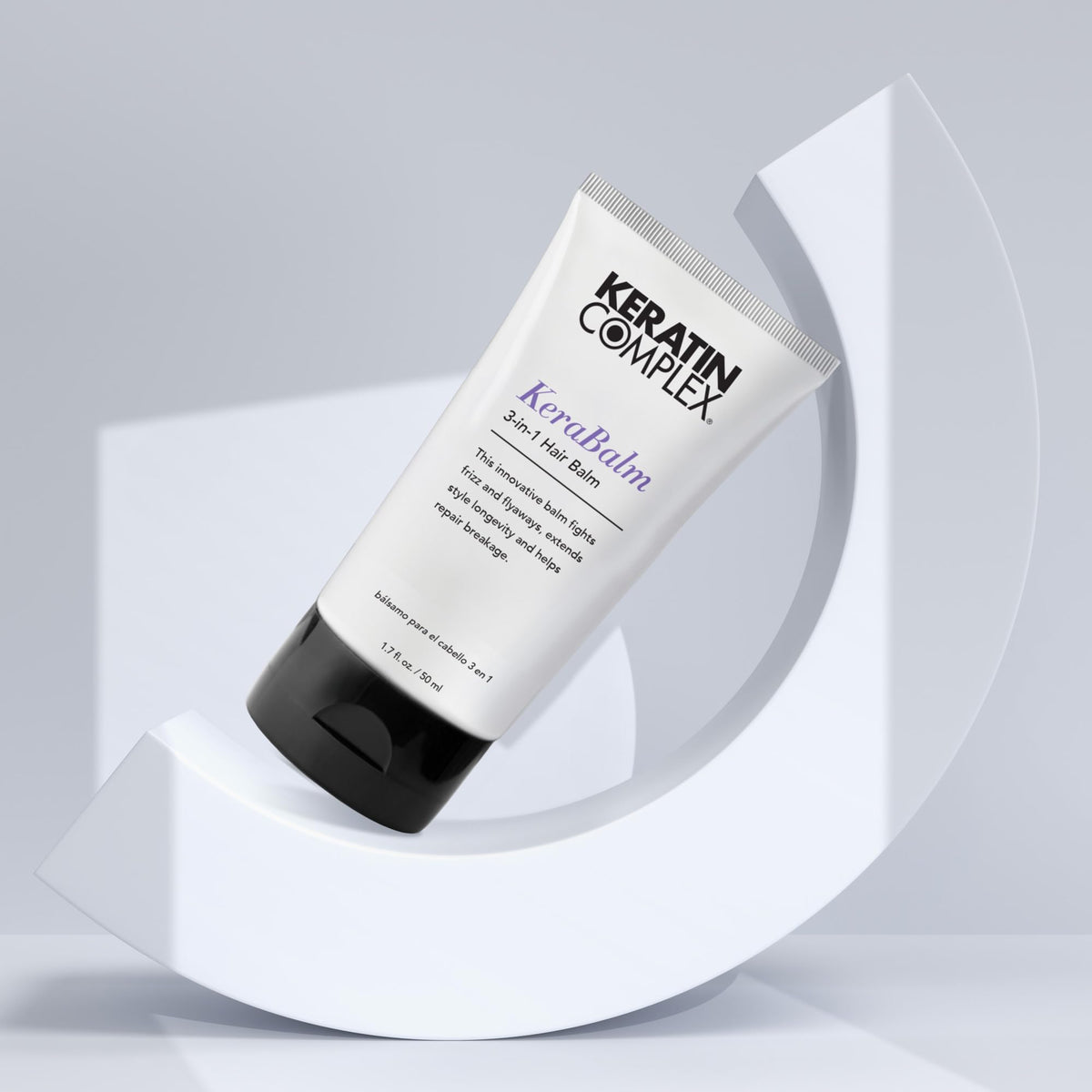 Keratin Complex size scale next to hand shows compact travel-friendly bottle