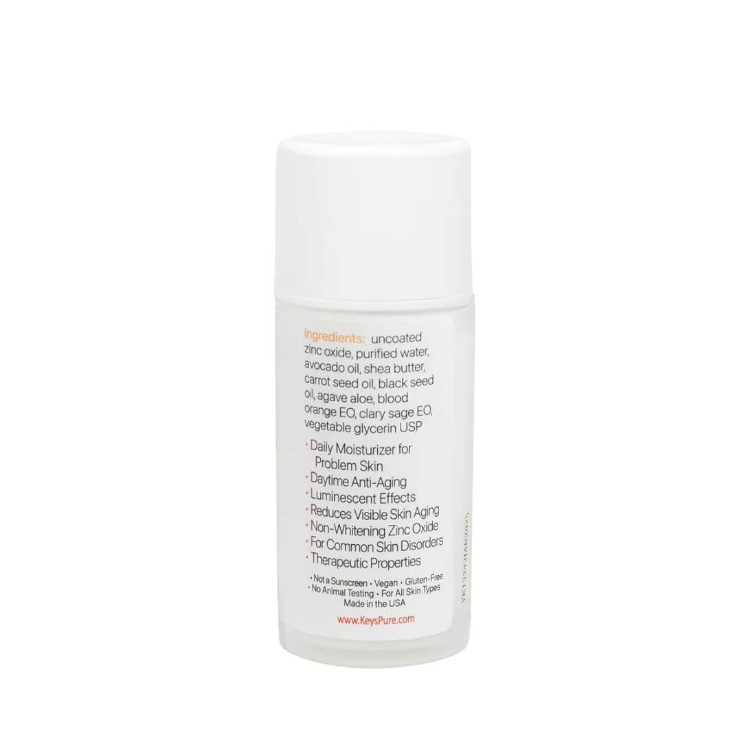 Keys Luminos PLUS cream texture close-up on fingertip, shows hydrating finish and zinc oxide benefit
