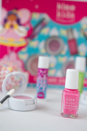 Klee Naturals kit beside child's hand showing compact size