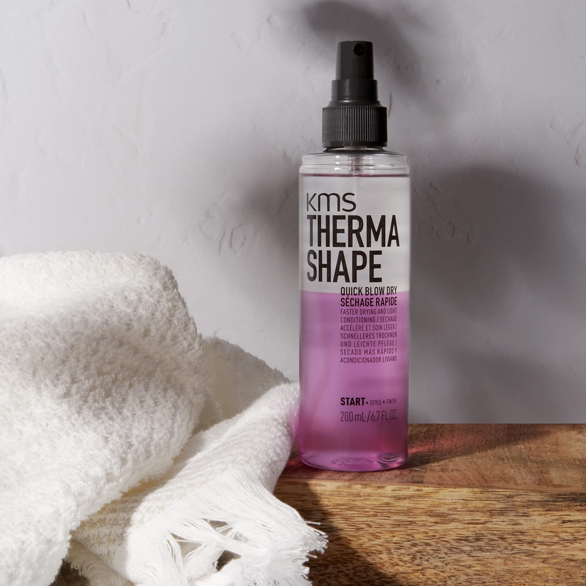 KMS THERMASHAPE spray in hand demonstrating easy application and quicker styling