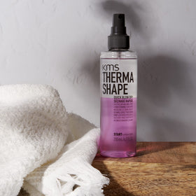 KMS THERMASHAPE spray in hand demonstrating easy application and quicker styling